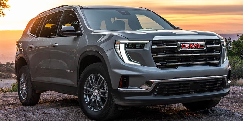 GMC SUV front view at sunset with bold grille and LED headlights.