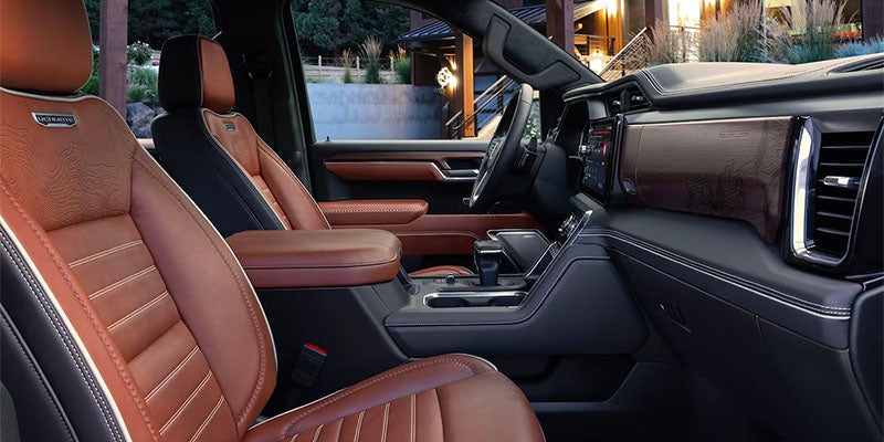 Luxurious brown leather interior of GMC truck with modern dashboard and center console.